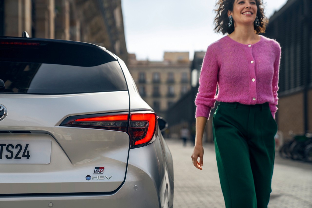 Toyota customer walking serenely next to her car