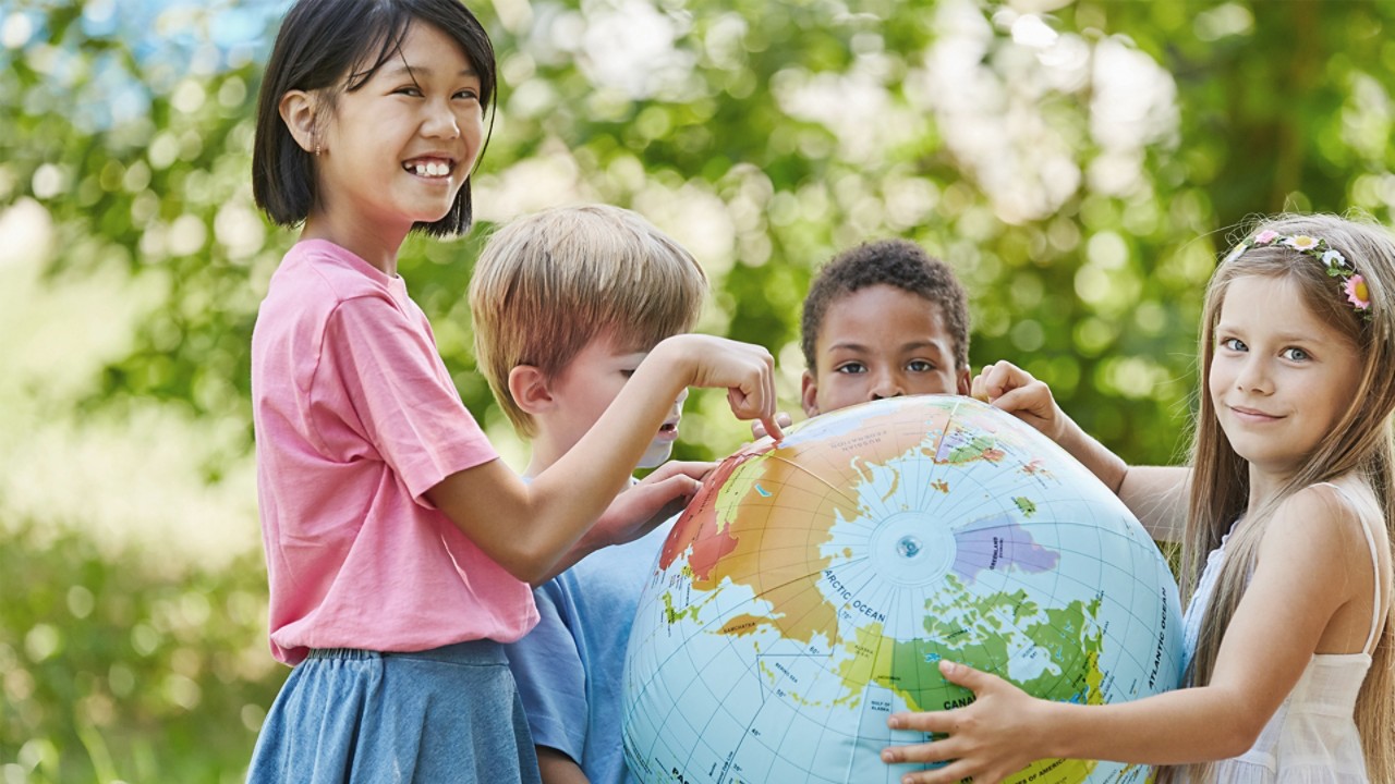 Children pointing Europe on a globe